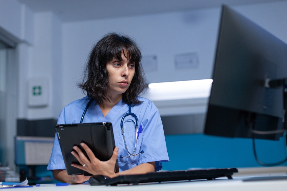 Medical worker looking at computer screen to track hospital assets
