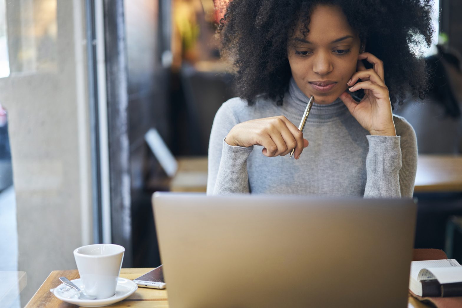 a woman sits looking at her laptop