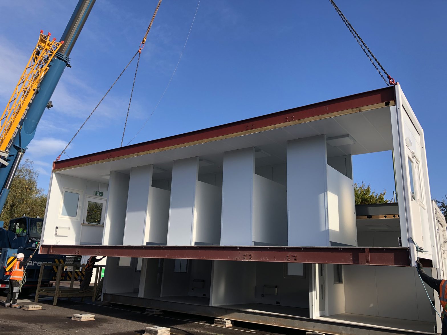 Construction of a modular building for COVID-19 testing site with crane and construction worker