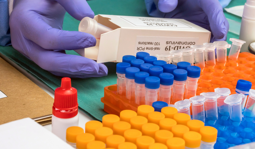 Person unpacking box with Covid-19 PCR kit in warehouse