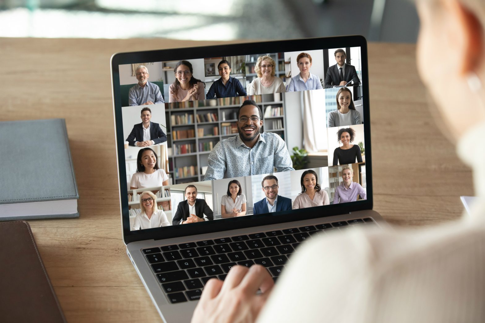 A woman sits looking at a video conference screen