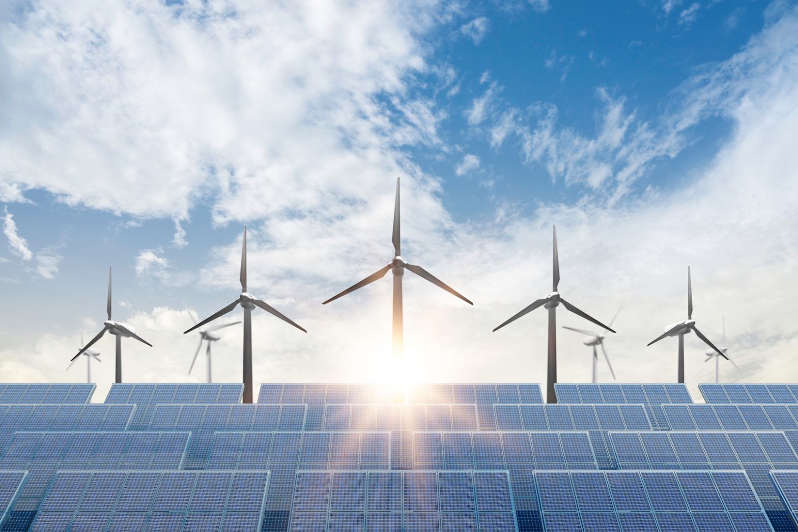 Wind turbines and solar panels with the sun setting