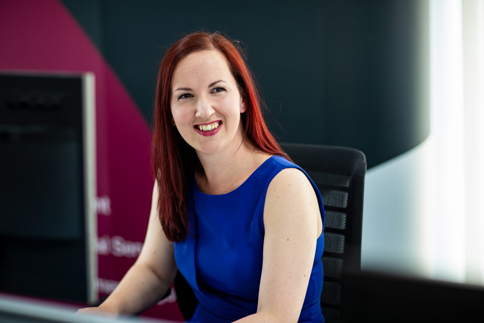 Charlene Maginnis sits at a desk