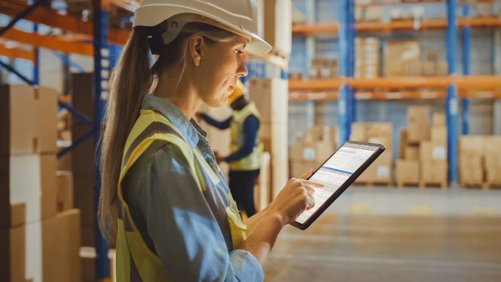 Professional female working in a warehouse on a tablet