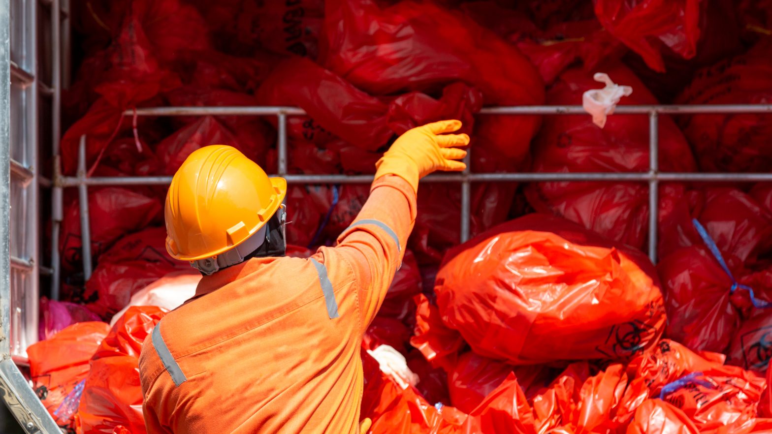 man throwing hazardous health waste into disposal area