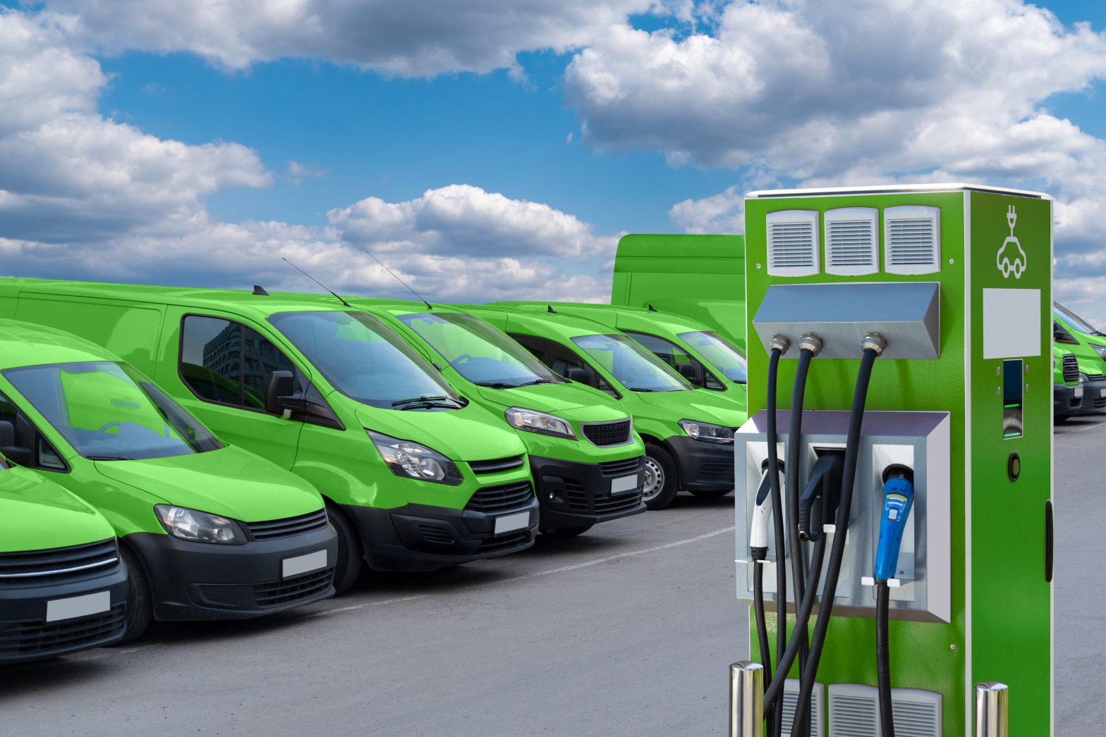 A line of green vehicles like vans and cars with an electric vehicle charging point.